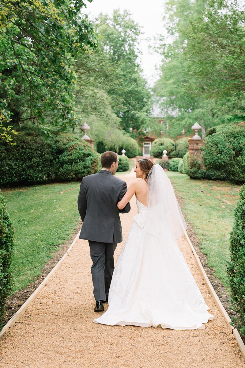 Wedding couple walking down gravel walkway